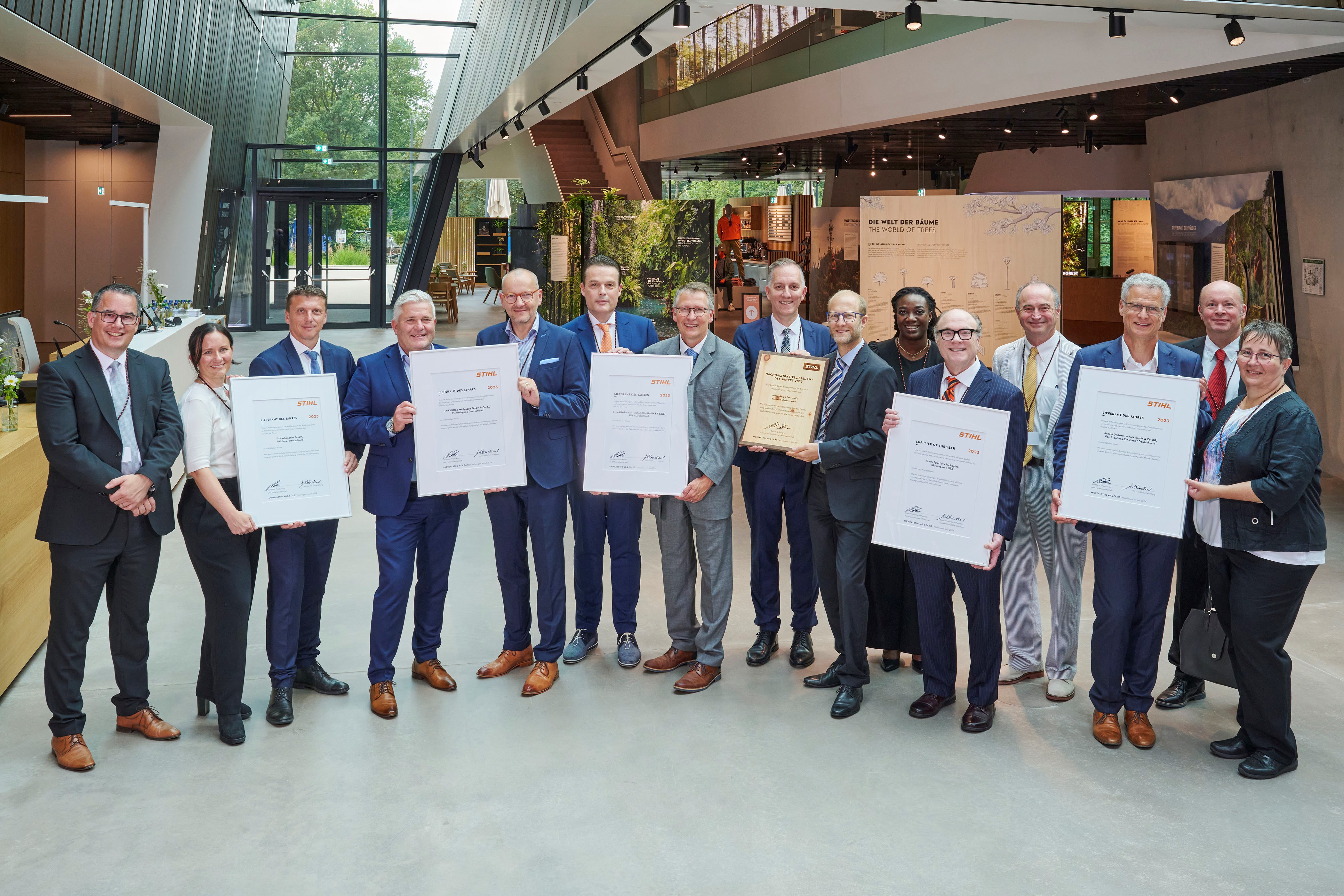Martin Schwarz, a STIHL gyártásért és anyagokért felelős igazgatósági tagja (balra) és Marc Moser, beszerzési alelnök (hátul jobbra) a STIHL Brand World díjnyertes beszállítóival.